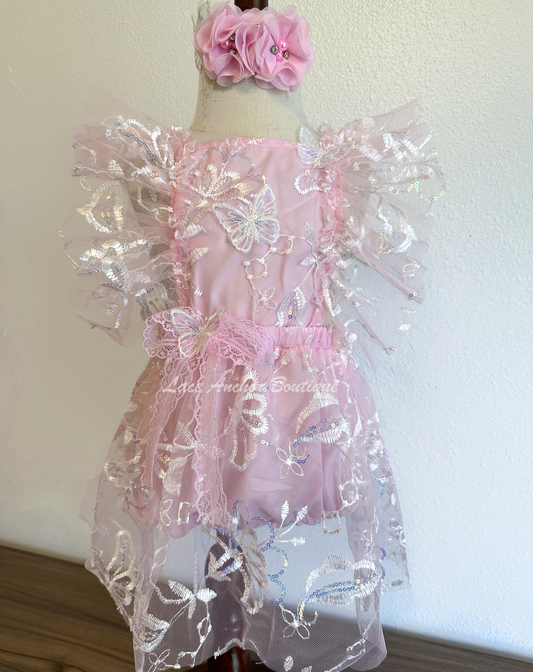 light pink baby girl romper. Glitter sequin romper dress with flutter sleeves, embroidered flowers, and sequin butterflies.