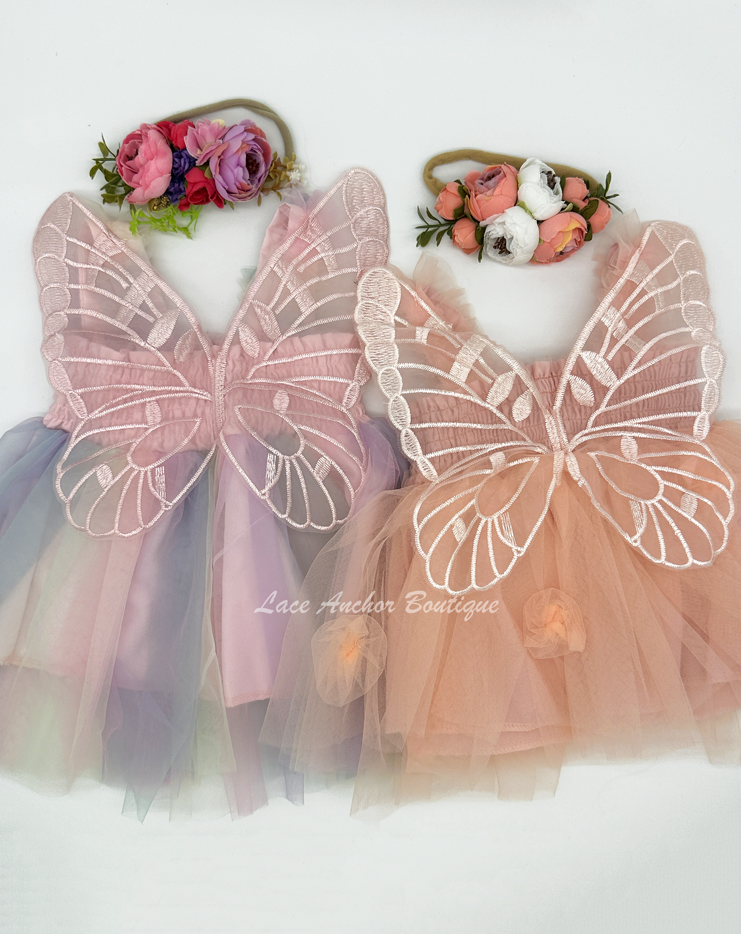 peachy with flowers or lilac, blue, pastel yellow, and blush colored tulle fairy girls dresses with smocked top and tulle flowers on skirt. Attached butterfly wings and ruffled straps.