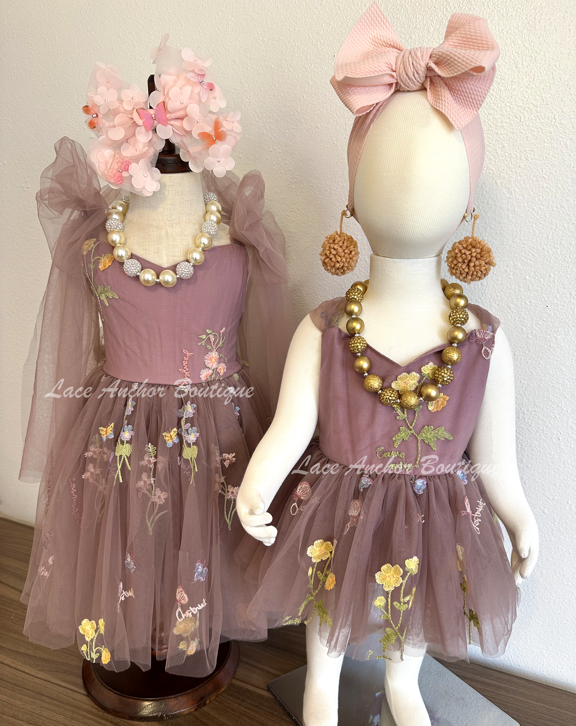 Baby girls romper with tied back fluffy bow. Outfits in deep plum purple with embroidered floral print.