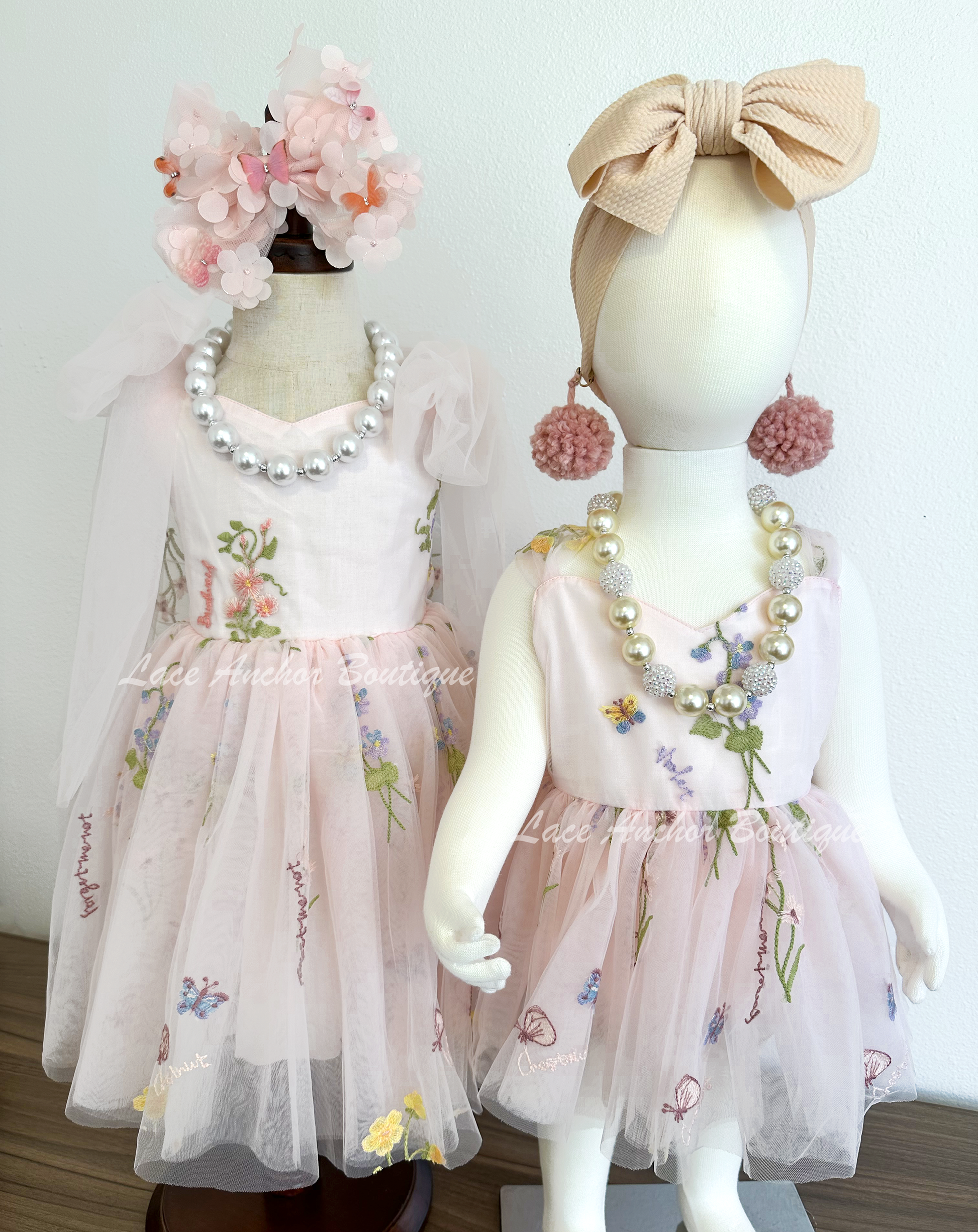 toddler youth puffy tied shoulder flower girl dress with large tied bow tied at waist. Baby girls romper with tied back fluffy bow. Outfits in light blush pink with embroidered floral print.