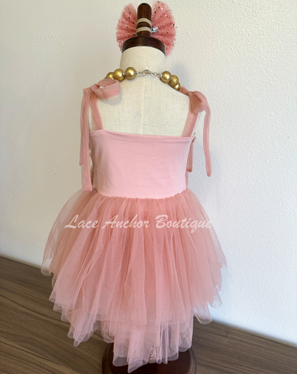 mauve rose pink girls dress with large bow in gold glitter star print witj rouched top and tied bow shoulder. Layered skirt.
