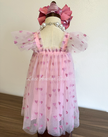 Light pink tulle tutu girls dress with glitter pink hearts and ruffled sleeves.