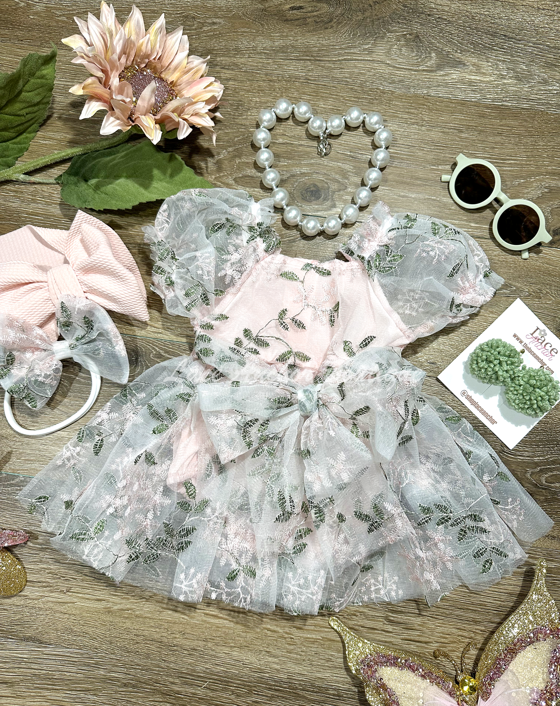 light blush pink embroidered floral rint skirted baby girls romper with large tied bow on front and puffed short sleeves. Baby toddler flower girl dress.