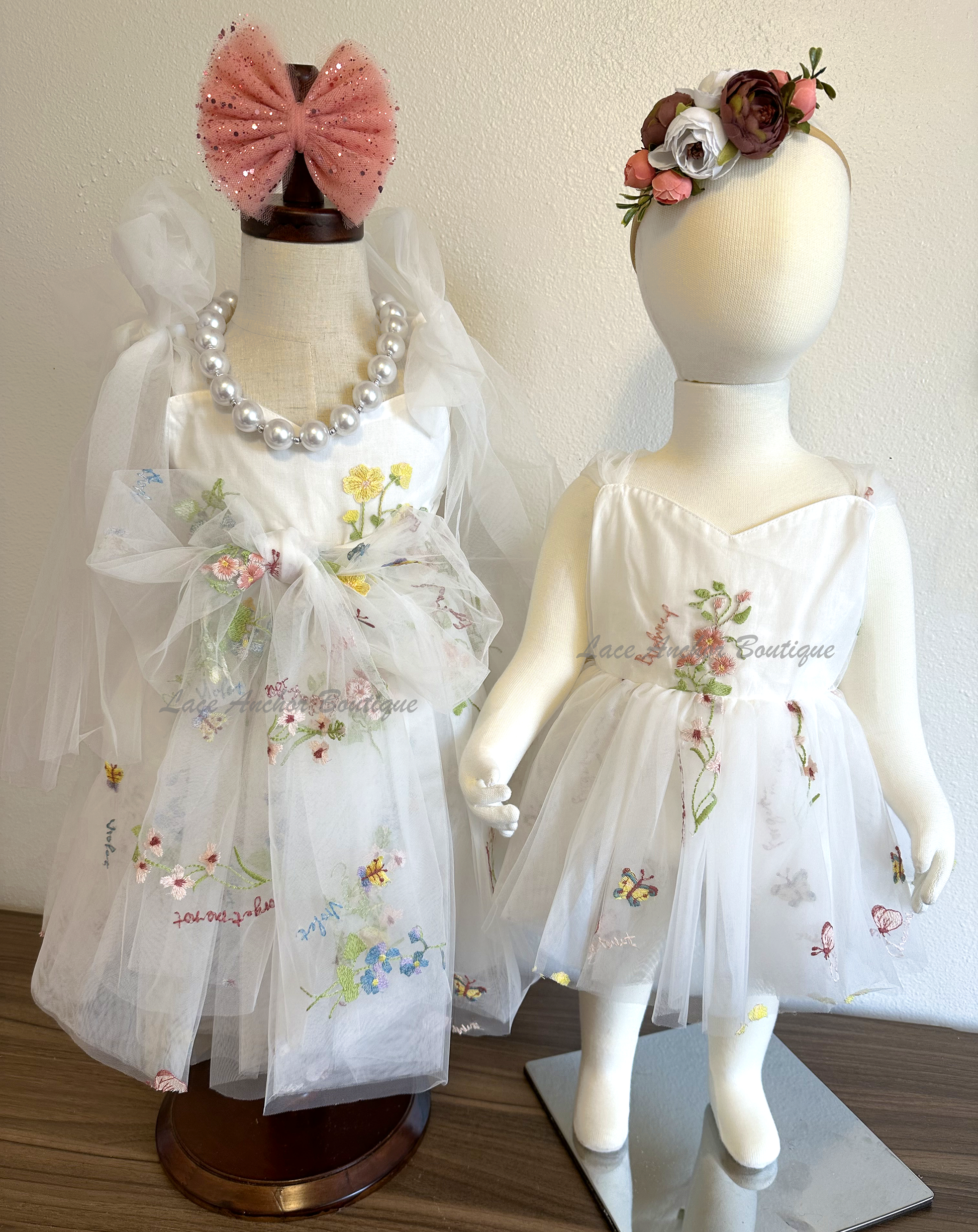 toddler youth puffy tied shoulder flower girl dress with large tied bow tied at waist. Baby girls romper with tied back fluffy bow. Outfits in white with embroidered floral print.