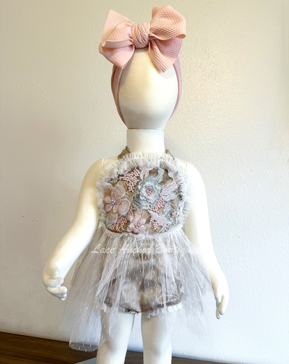baby girls aupe light brown romper with lace trim, ruffled detail, tulle skirt, and embroidered floral flower top with tied halter straps. Baby girl flower girl outfit.