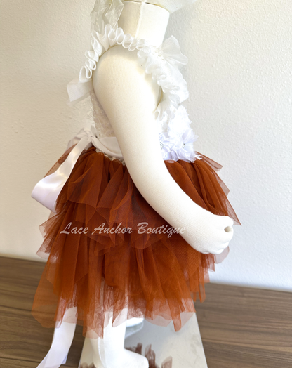 flower girls short dress with rust copper tulle skirt, white lace top with flutter sleeves, pearl beading, and white floral tied sash