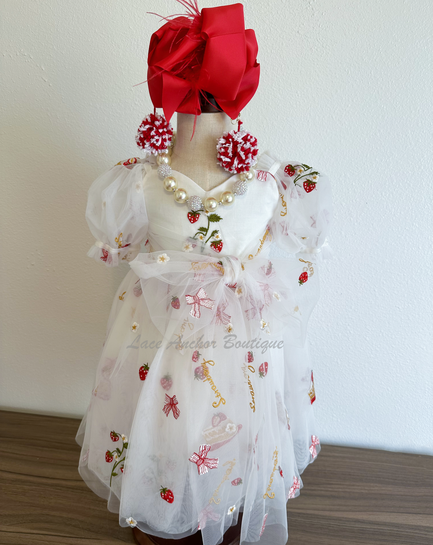 white dress with strawberries, bows, and strawberry shortcake embroidered print with large fluffy tied bow and puff sleeves.