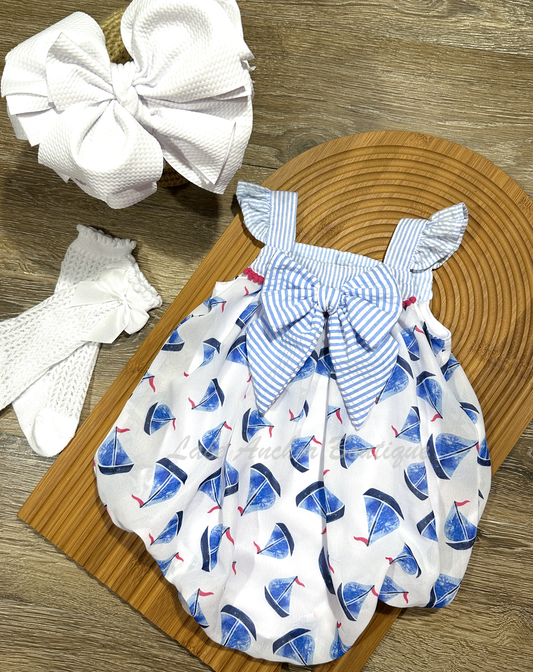 upcycled thrifted white bubble baby girls romper with blue and white gingham top, gingham sailor bow, and blue and hot pink sailboat print all over.