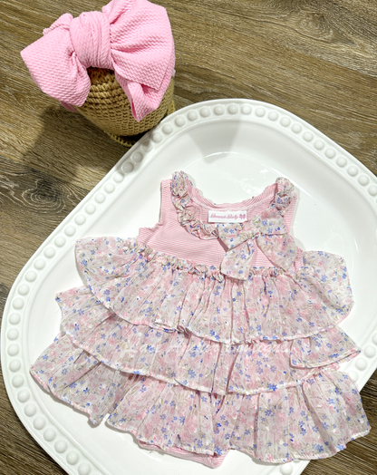 light pink striped romper with floral chiffon ruffles. Baby girl dress with bow, ruffles, and snaps.