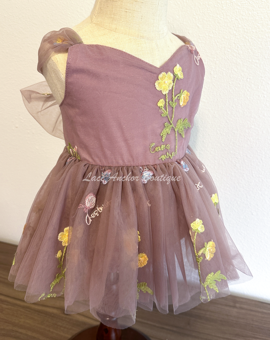 Baby girls romper with tied back fluffy bow. Outfits in deep plum purple with embroidered floral print.