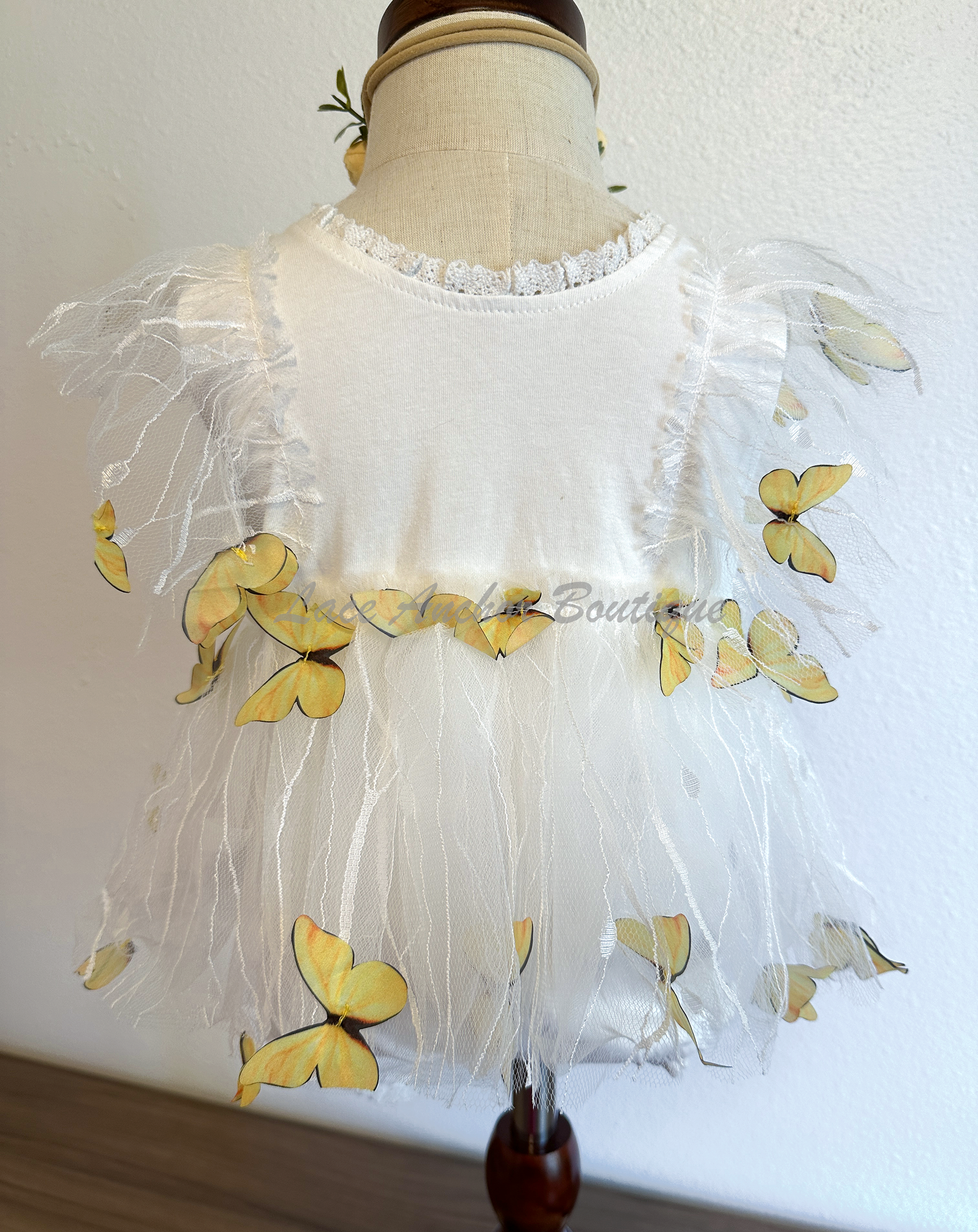 white baby girls romper with floral embroidery, tulle, lace, and butterflies all over