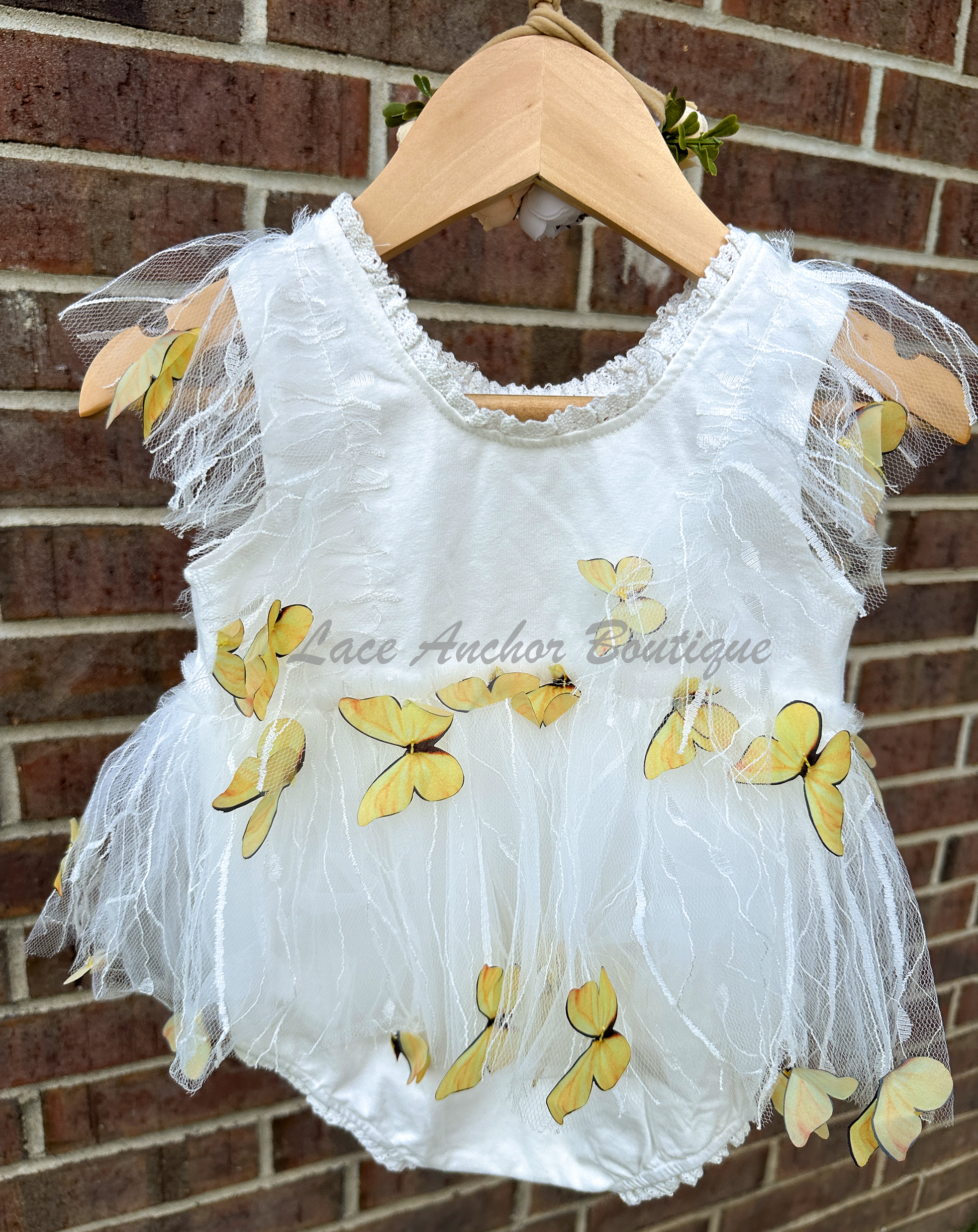 white baby girls romper with floral embroidery, tulle, lace, and butterflies all over