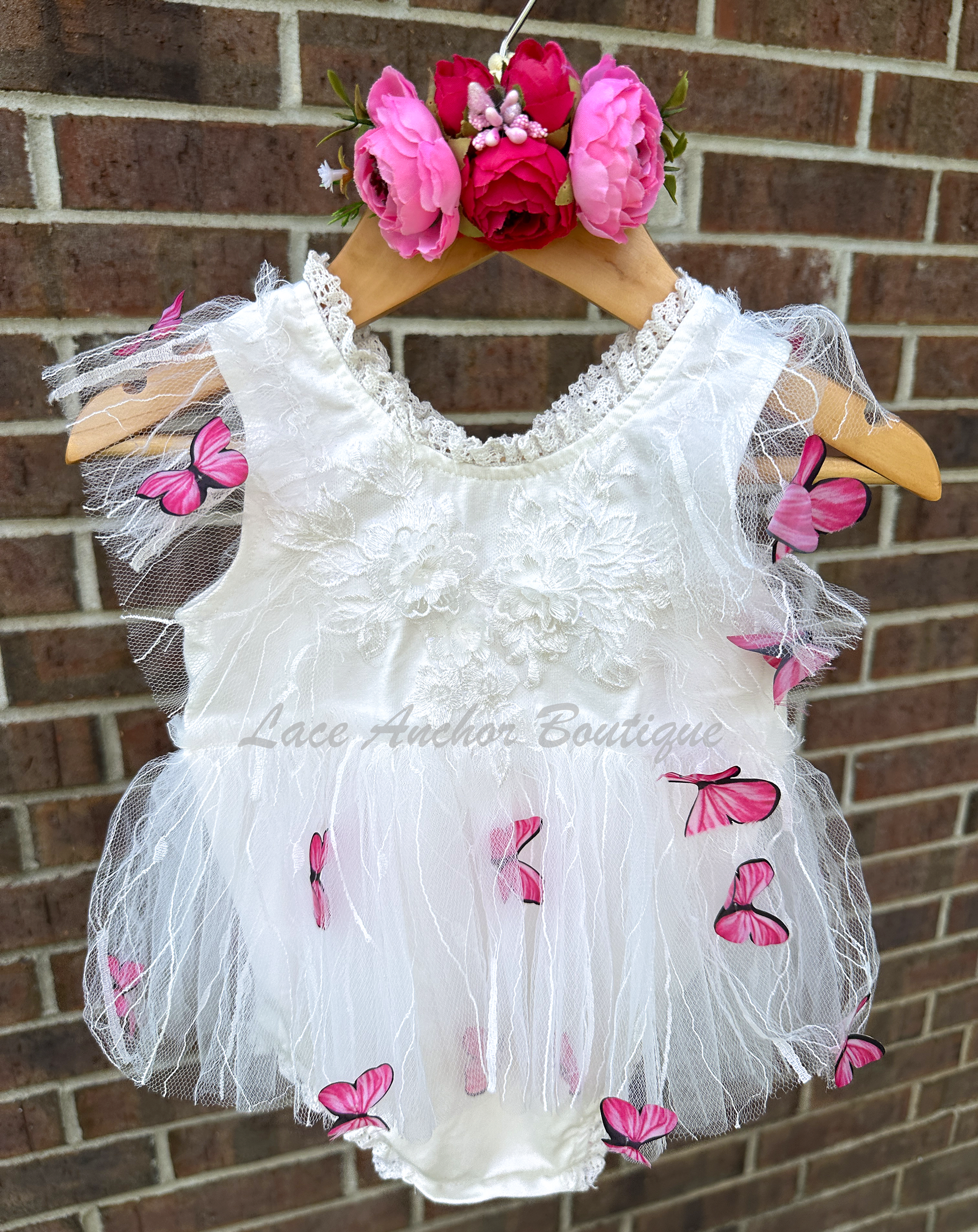 white baby girls romper with floral embroidery, tulle, lace, and butterflies all over