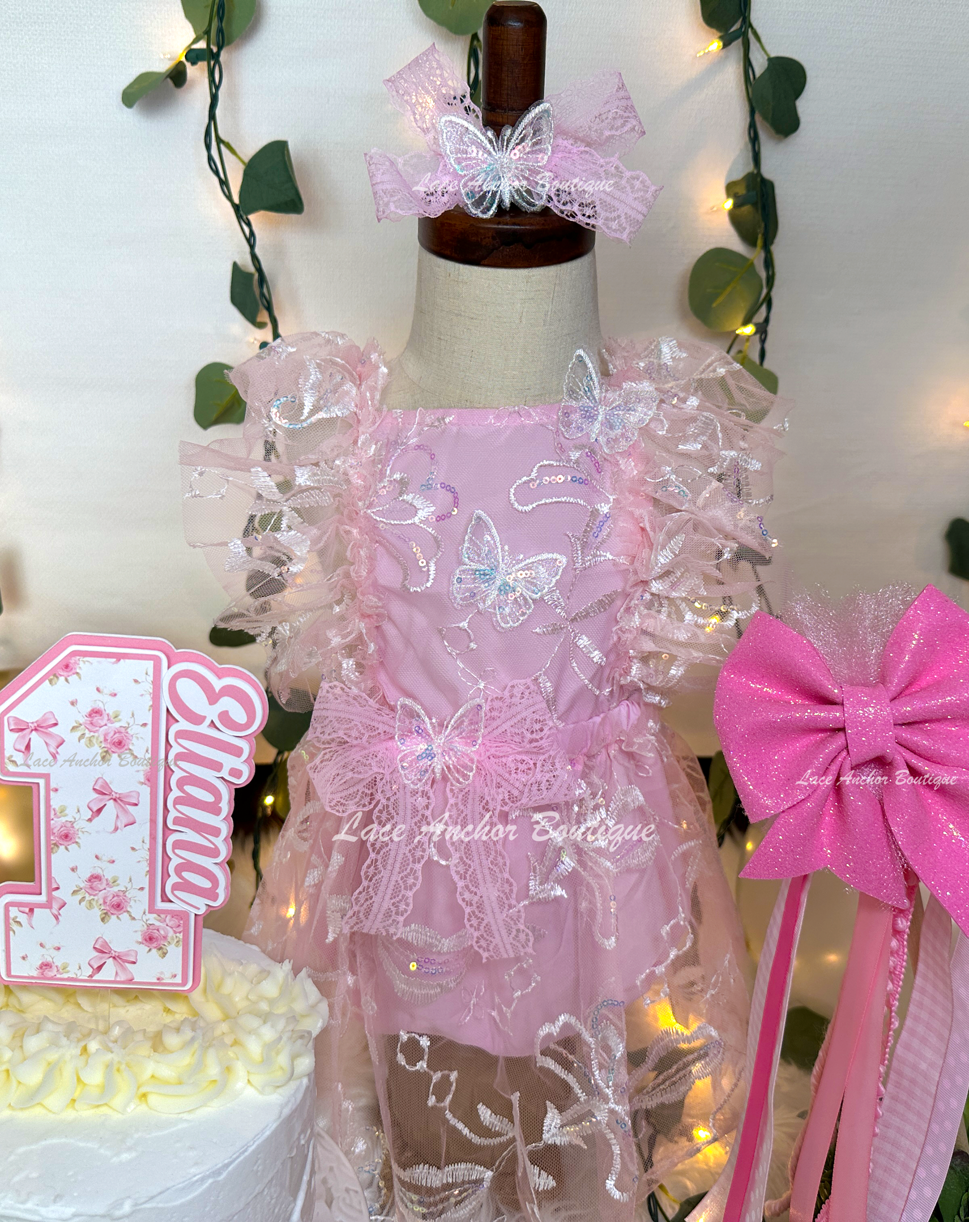 light pink baby girl romper. Glitter sequin romper dress with flutter sleeves, embroidered flowers, and sequin butterflies.