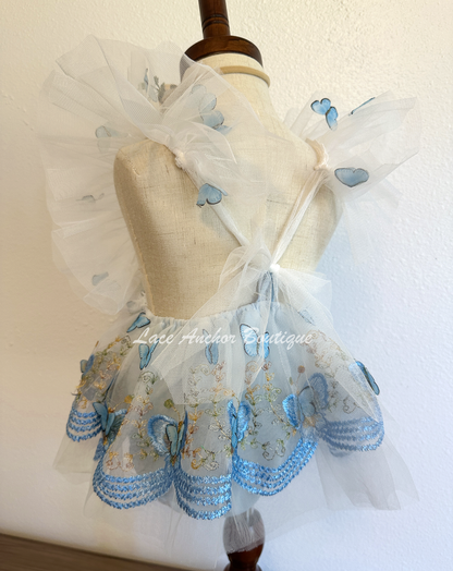 baby girls romper with flutter sleeves and skirt. Made of tulle with embroidered floral design and matching realistic butterflies all over in light blue.