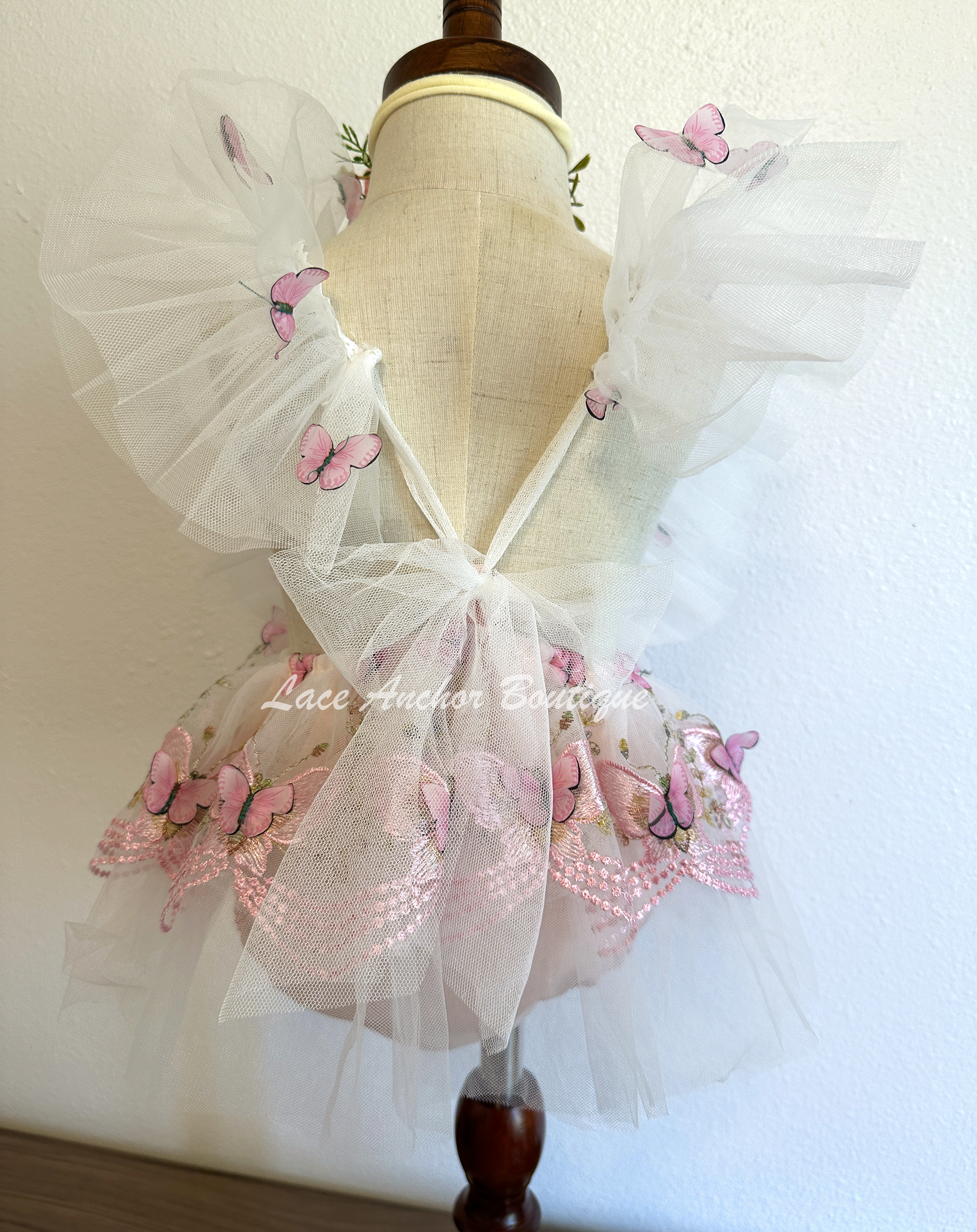 baby girls romper with flutter sleeves and skirt. Made of tulle with embroidered floral design and matching realistic butterflies all over in blush light pink.