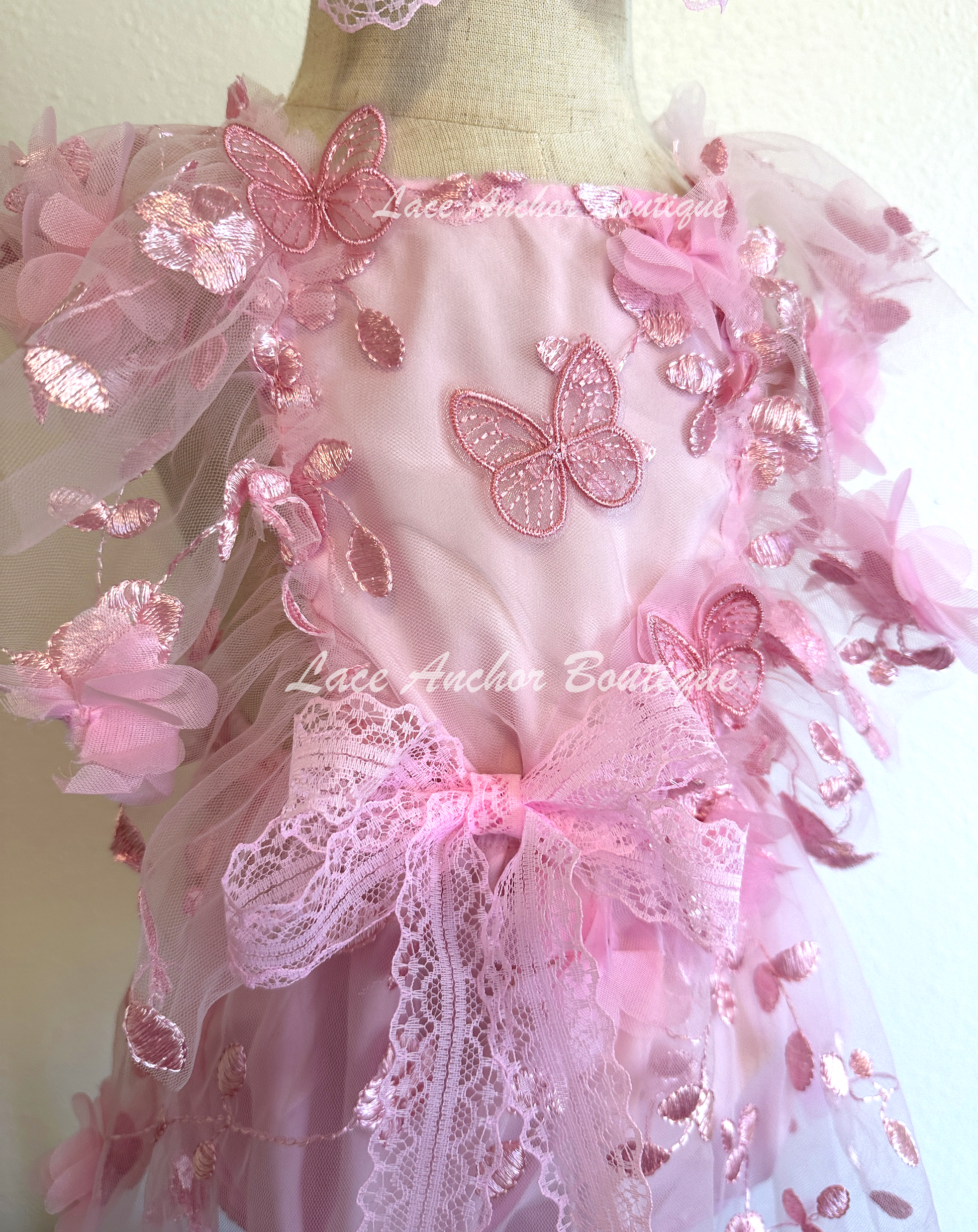 light pink baby girl romper. Butterfly floral romper dress with flutter sleeves, embroidered flowers, and butterflies.