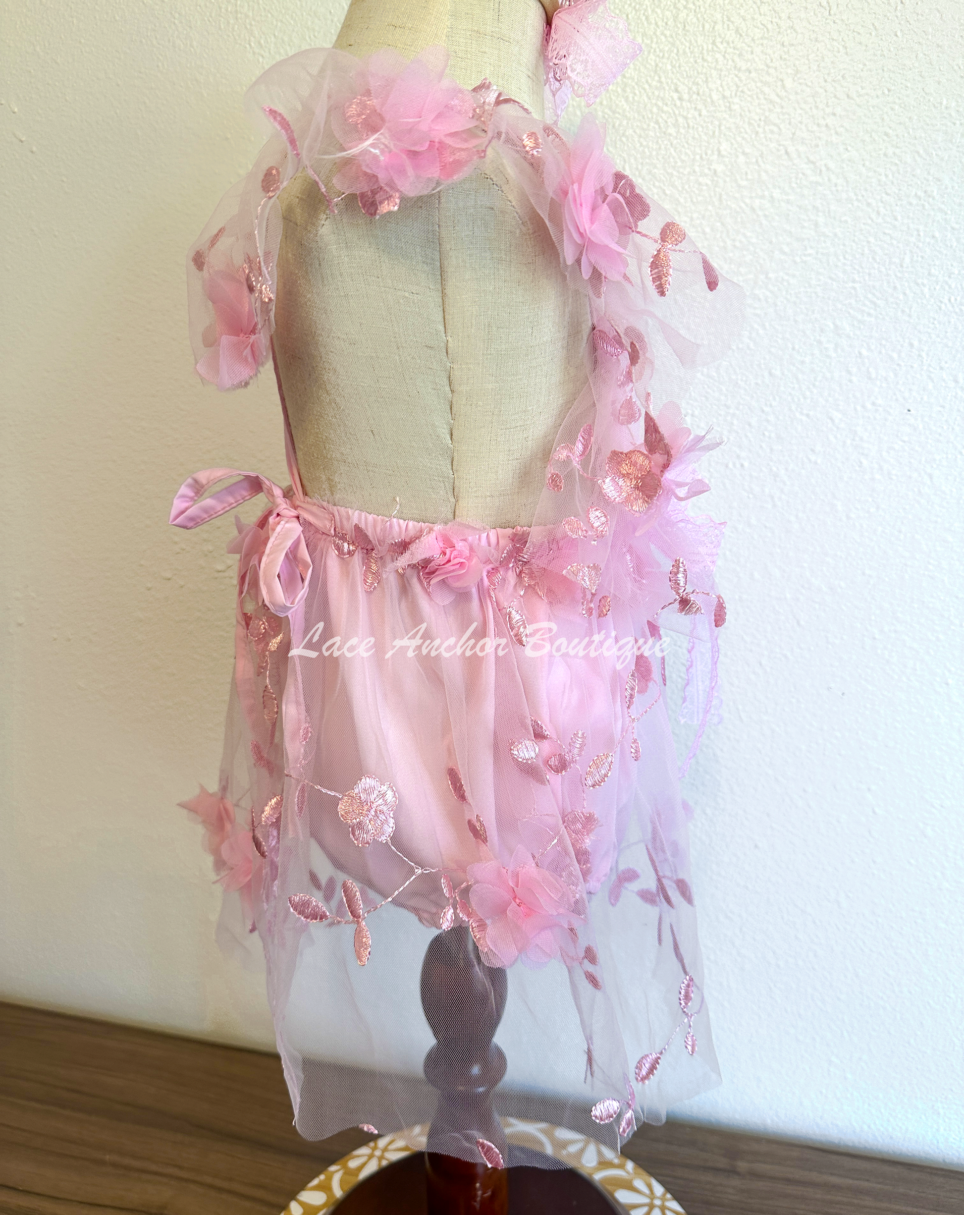 light pink baby girl romper. Butterfly floral romper dress with flutter sleeves, embroidered flowers, and butterflies.