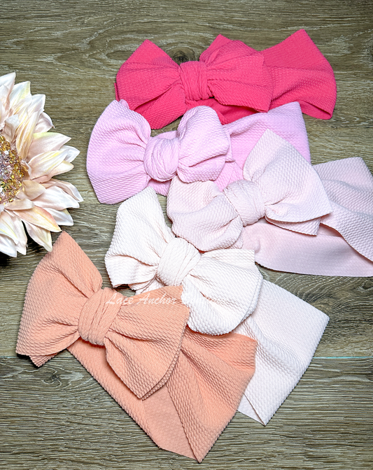 bullet fabric baby girls wrap style hair bows in various shapes of pink.