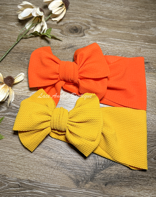 bold colored solid orange and solid mustard yellow bullet fabric headwraps for babies. Baby girl big bow hair bows.