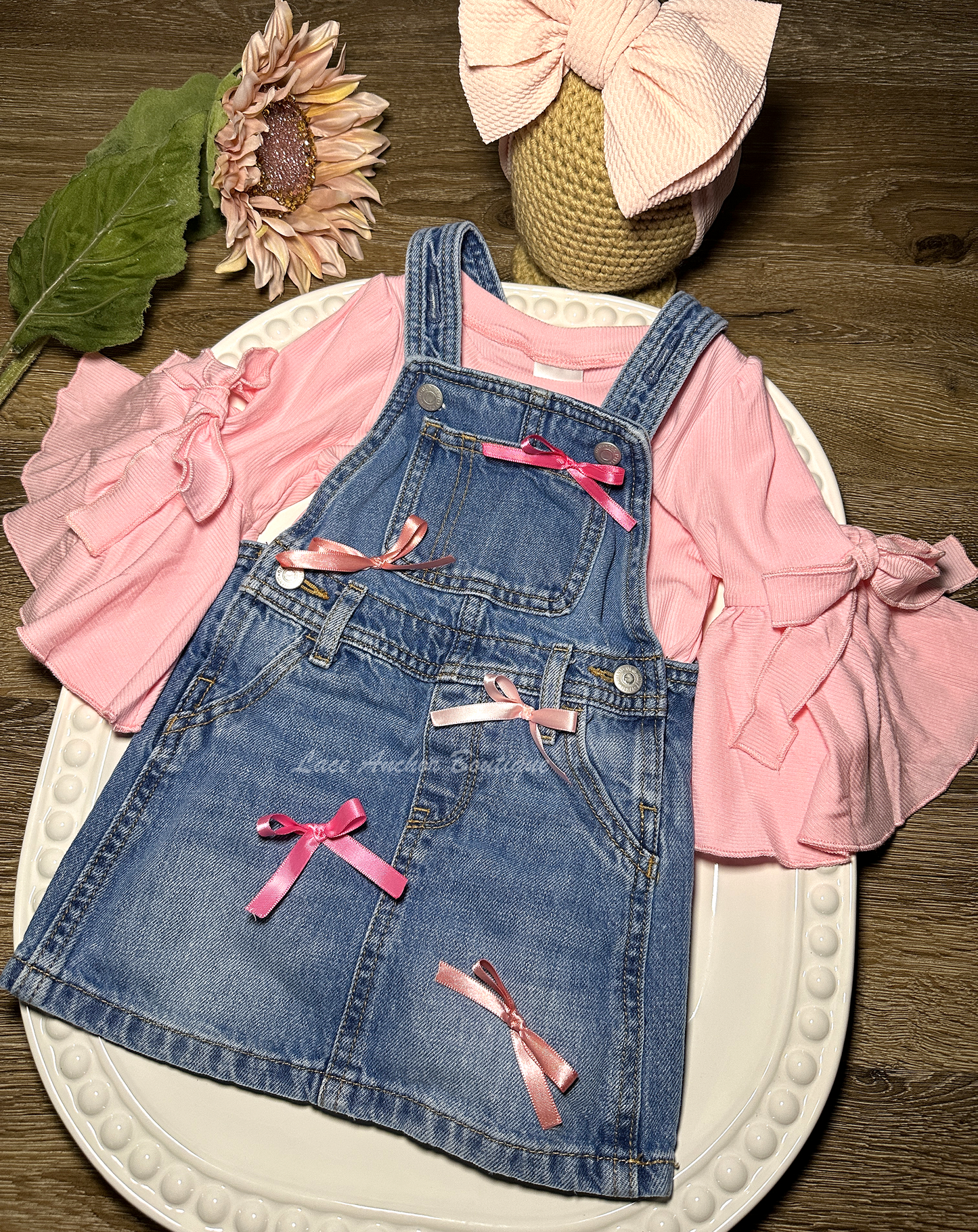 toddler girls blue denim overalls in a skirt style with multi colors of pink silky bows