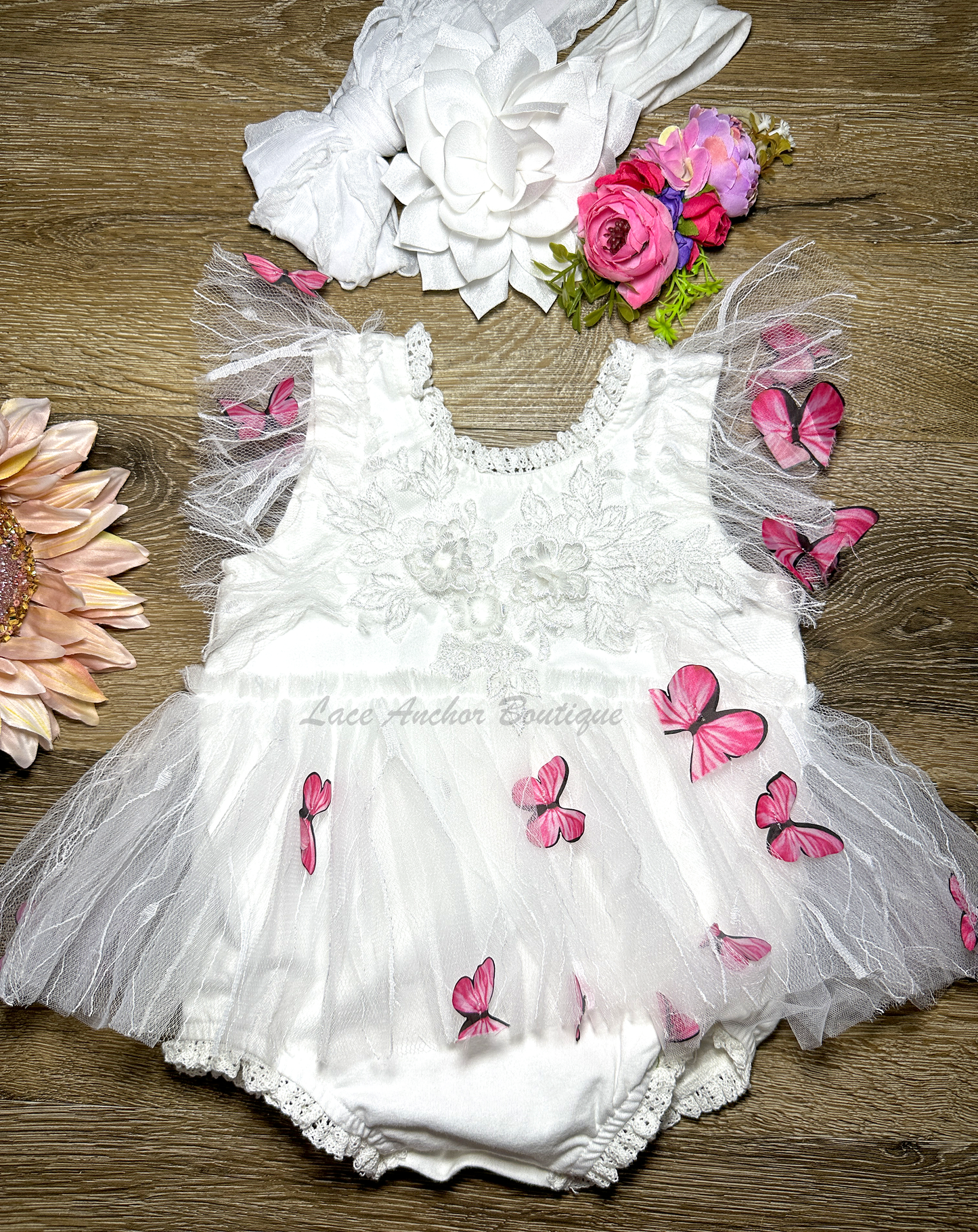 white baby girls romper with floral embroidery, tulle, lace, and butterflies all over