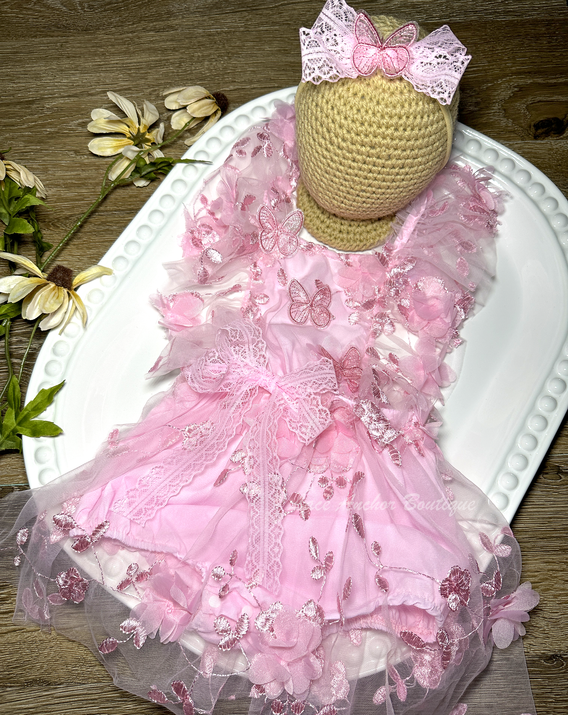 light pink baby girl romper. Butterfly floral romper dress with flutter sleeves, embroidered flowers, and butterflies.