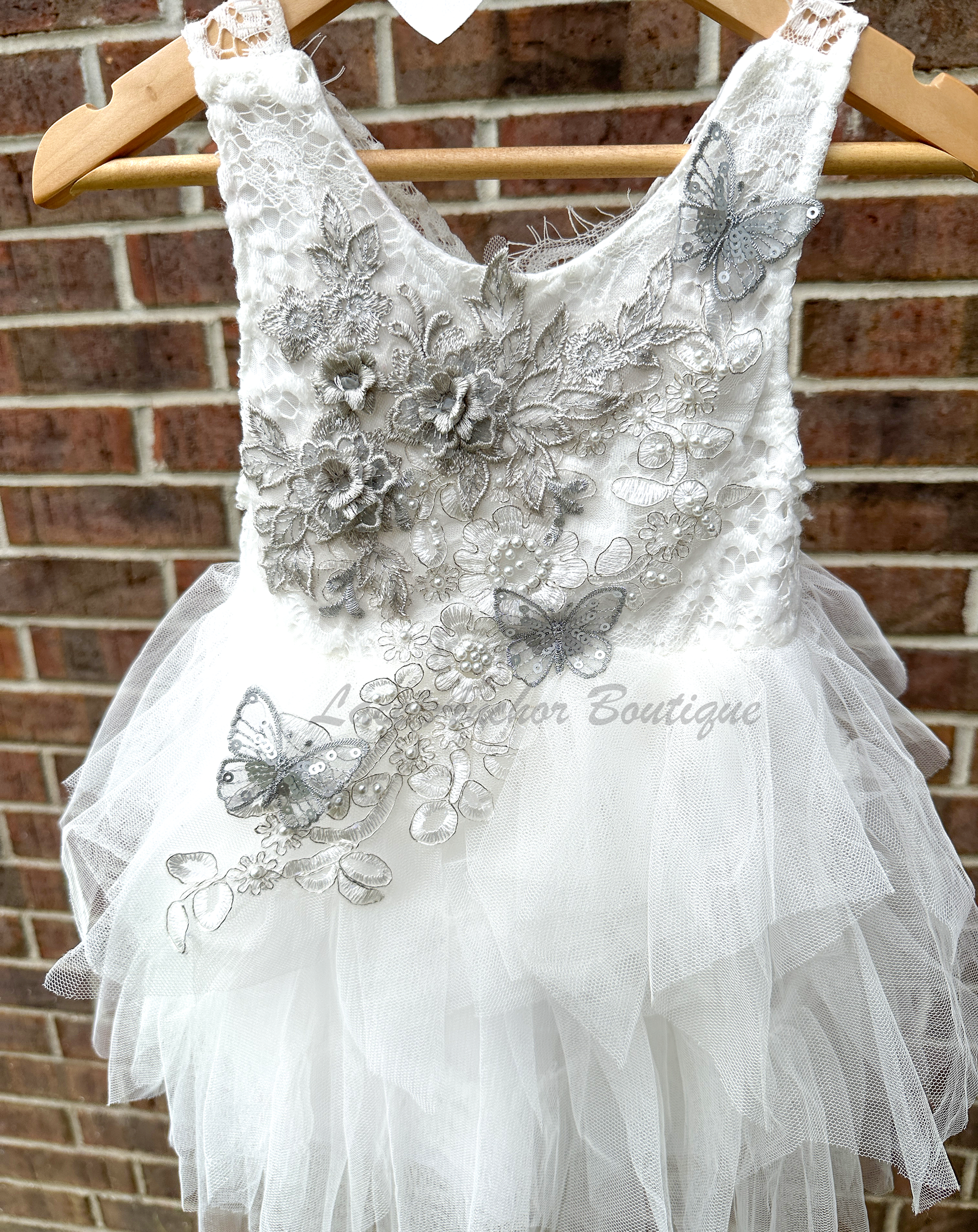 white girls dress with embroidered floral applique in silver with pearls and silver sequin butterflies