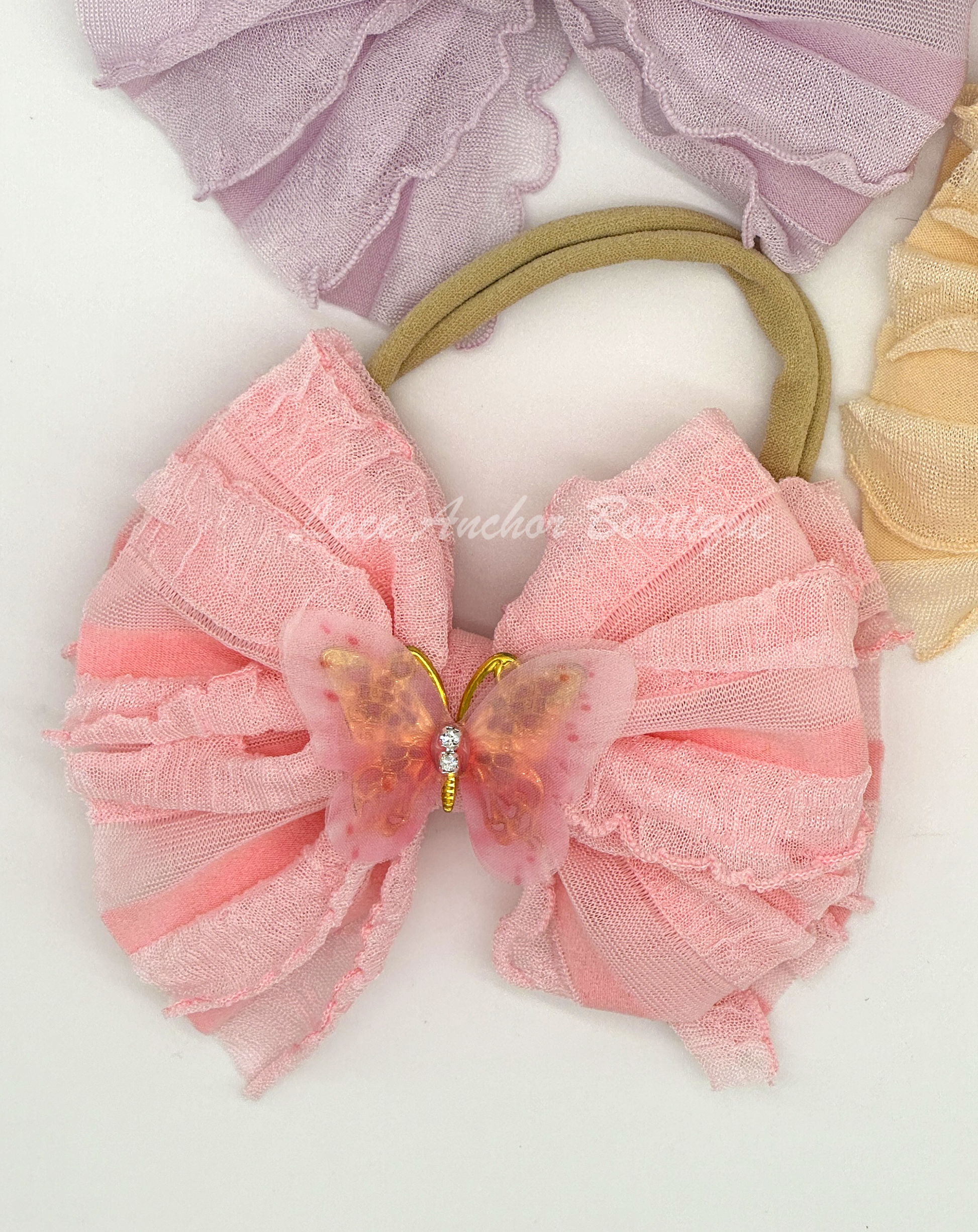 baby and toddler ruffle frilly bow on nylon band with butterfly center in light pink