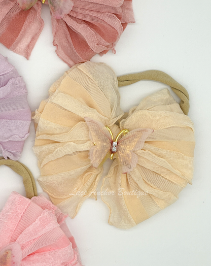 baby and toddler ruffle frilly bow on nylon band with butterfly center in light peach