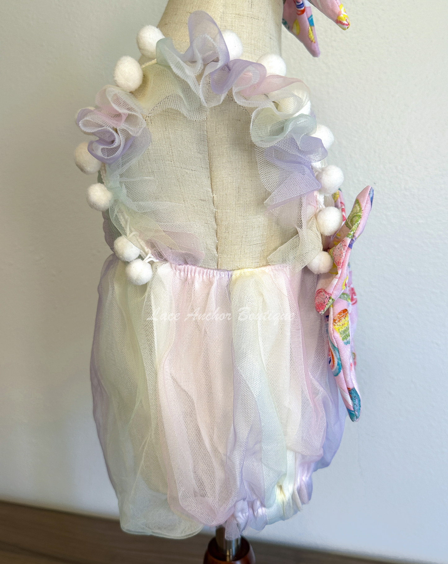 baby girls pastel lilac purple, yellow, blue, blue pink smocked tulle romper with candy themed big bow and matching hair bow with 3D sucker through it. Sweet One Candy Land Themed Outfit for birthday Photoshoots.