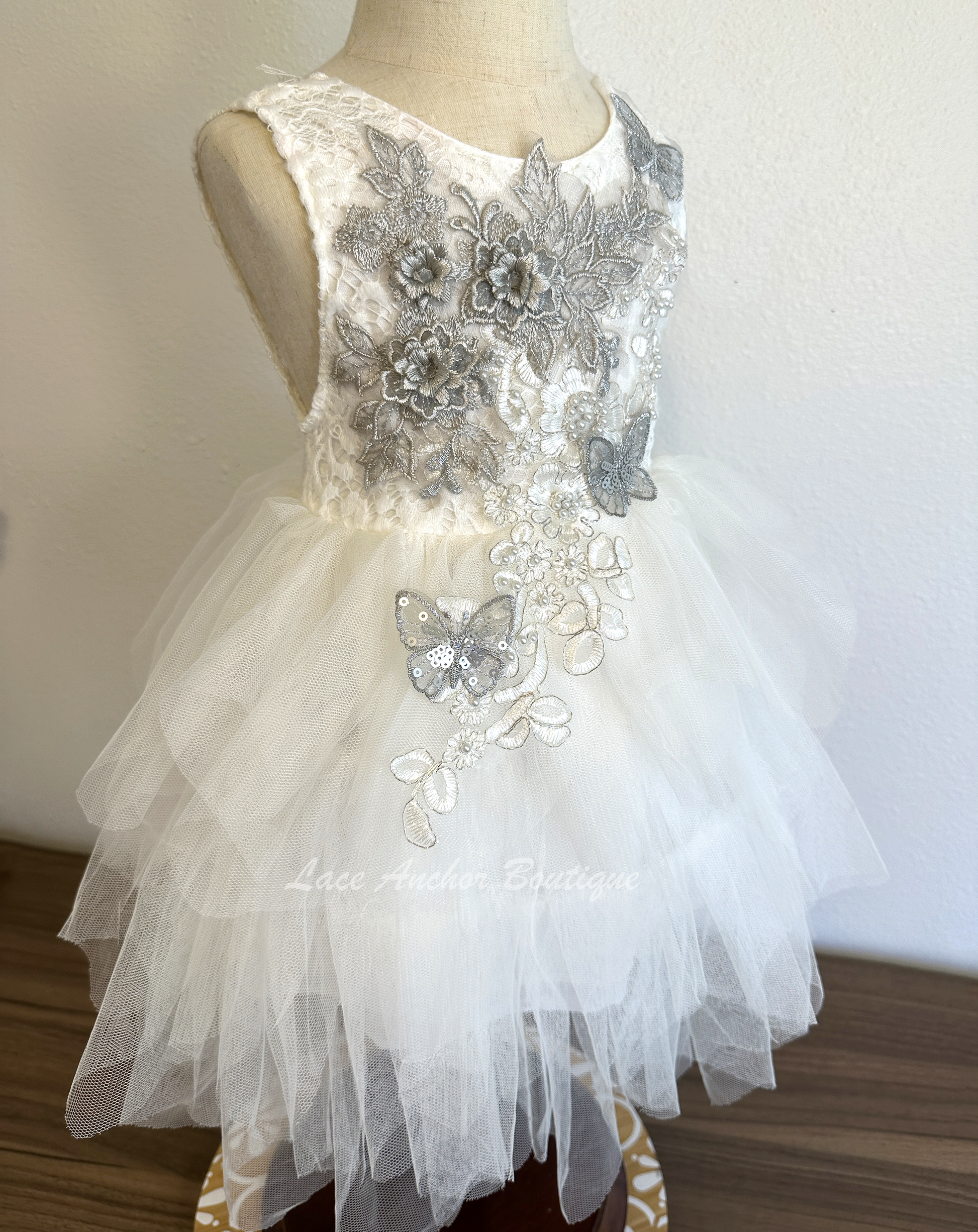 white girls dress with embroidered floral applique in silver with pearls and silver sequin butterflies