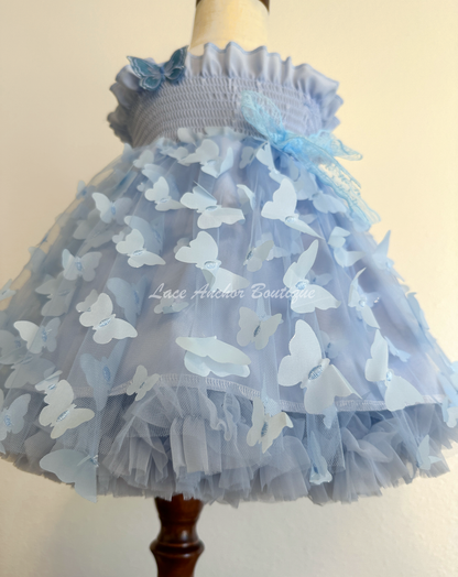 light blue girls butterfly wing fairy dress in pink on model child toddler. Has butterflies all over skirt.