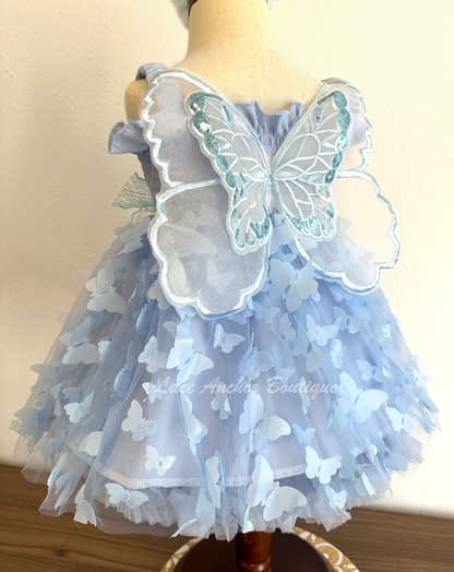 light blue girls butterfly wing fairy dress in pink on model child toddler. Has butterflies all over skirt.