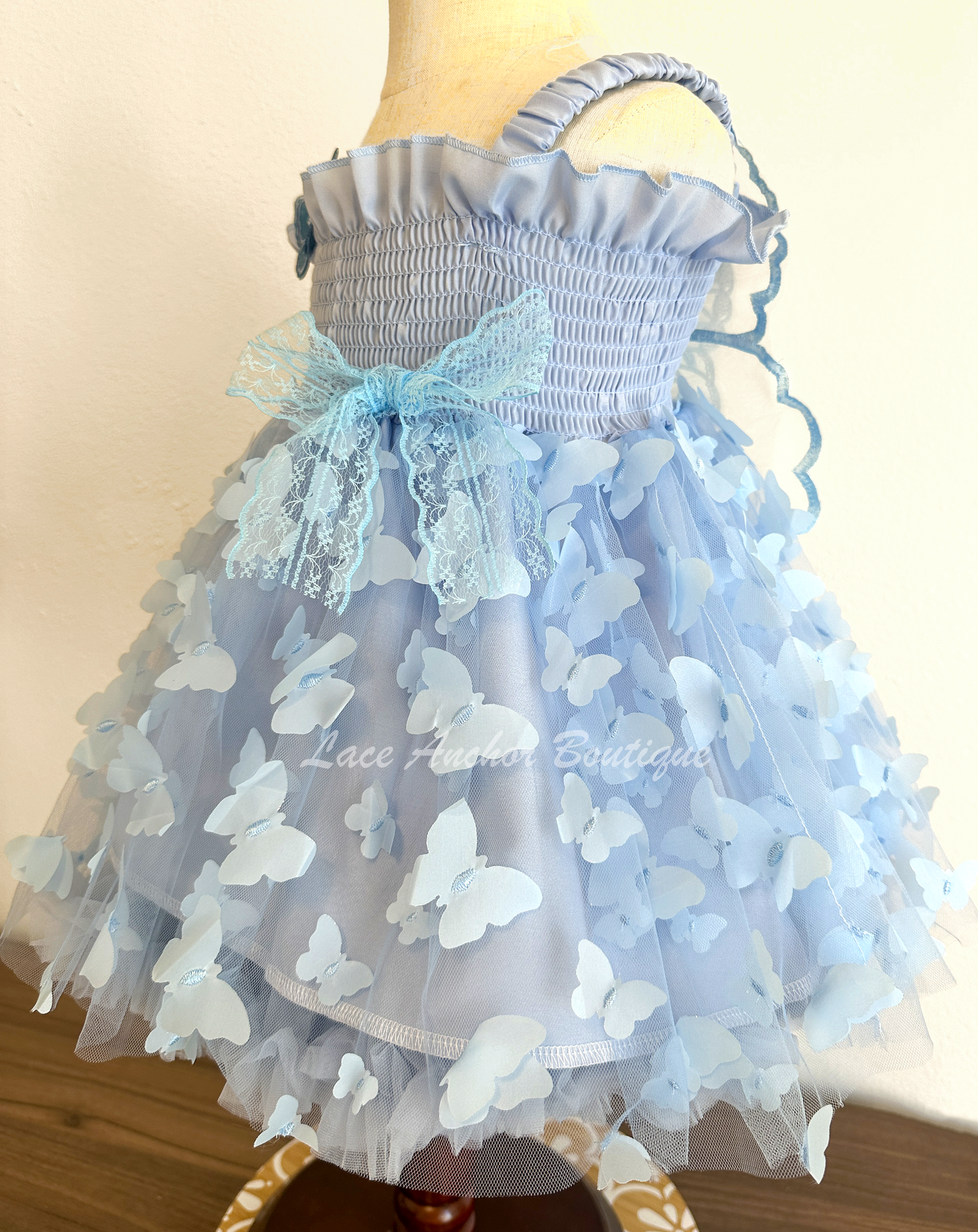 light blue girls butterfly wing fairy dress in pink on model child toddler. Has butterflies all over skirt.