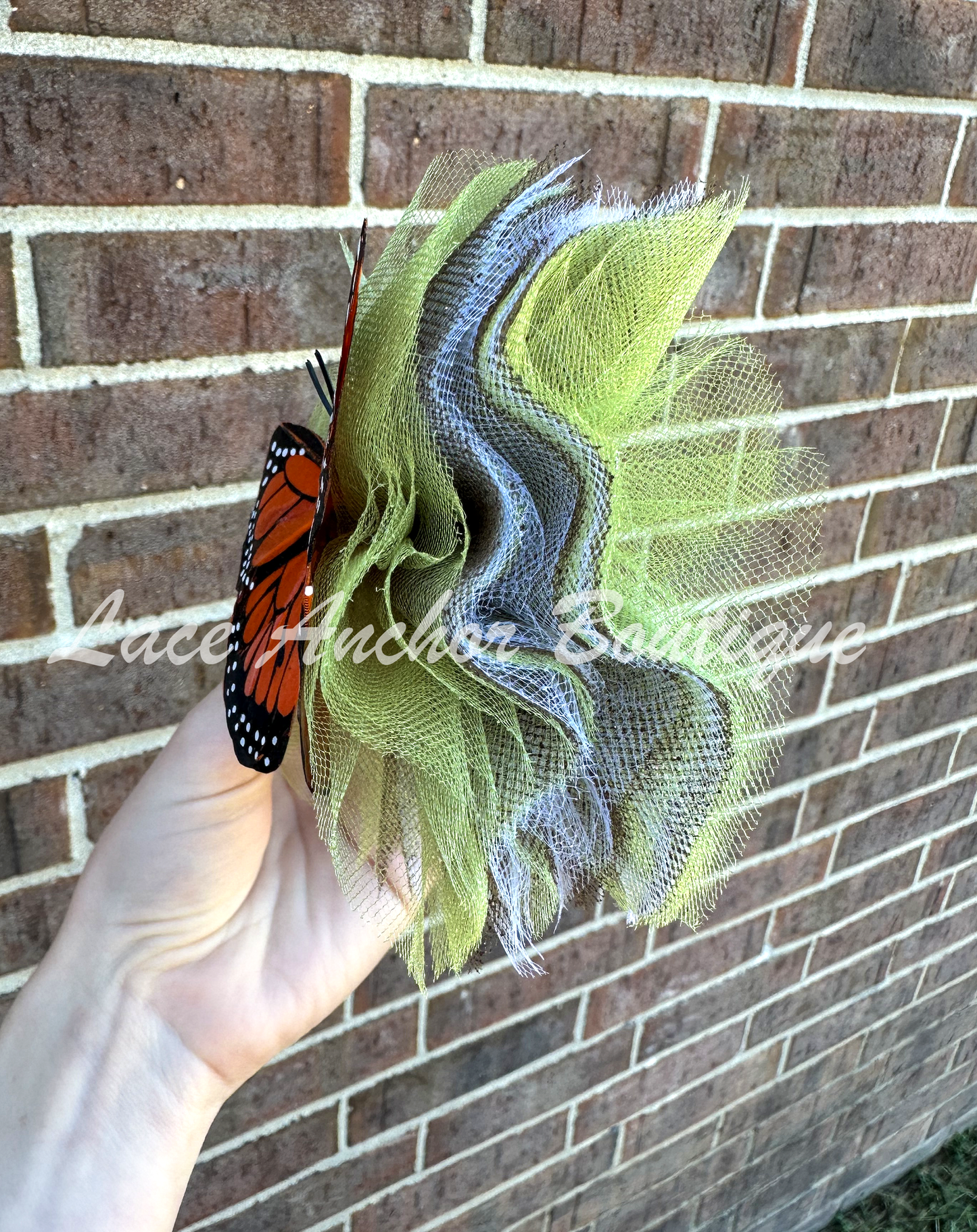 sage green tulle girls hair bow with orange monarch butterfly center. Girl clip hair bow.