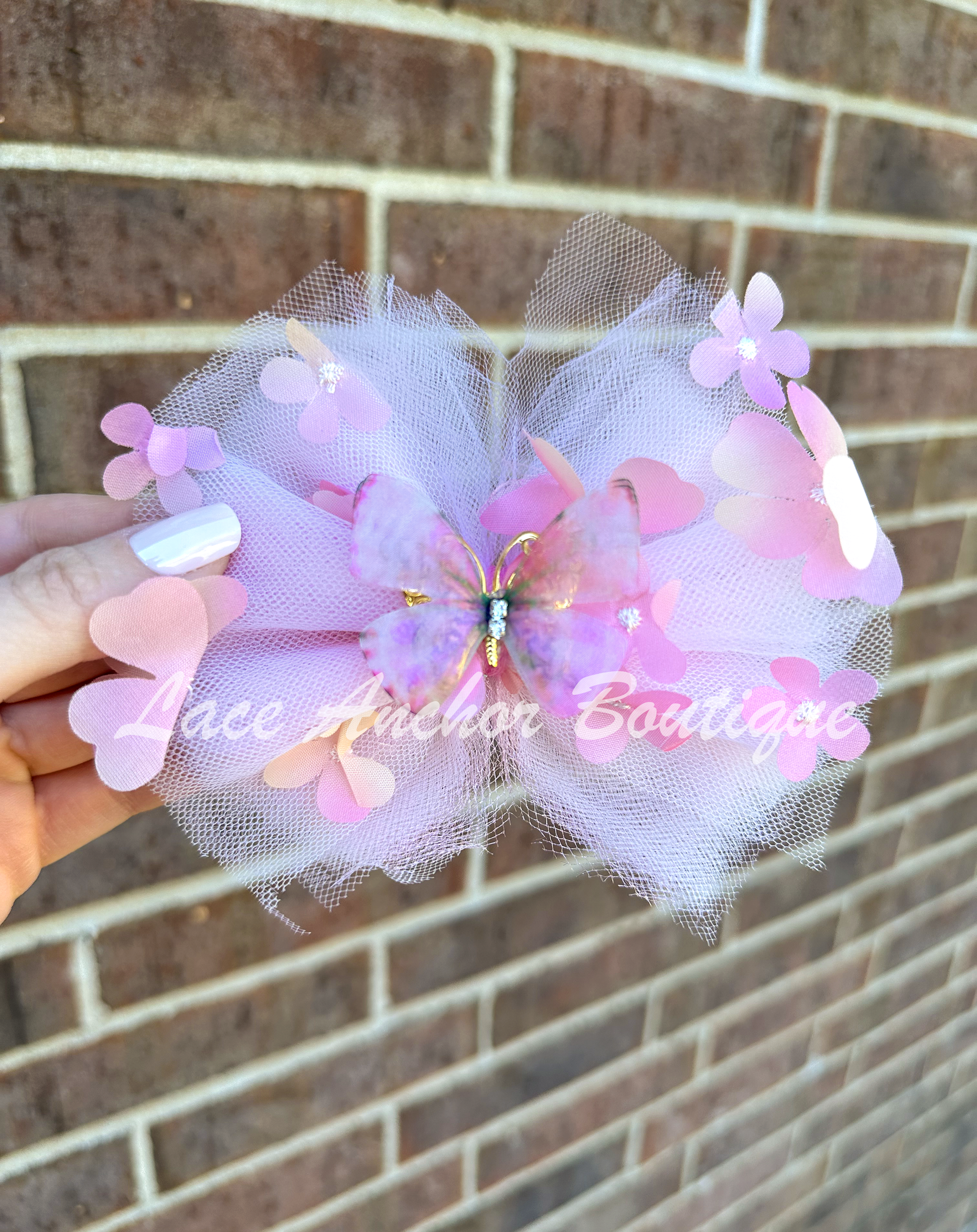 light pink tulle hair bow with flowers and pink and gold butterfly center for toddler girls and up..