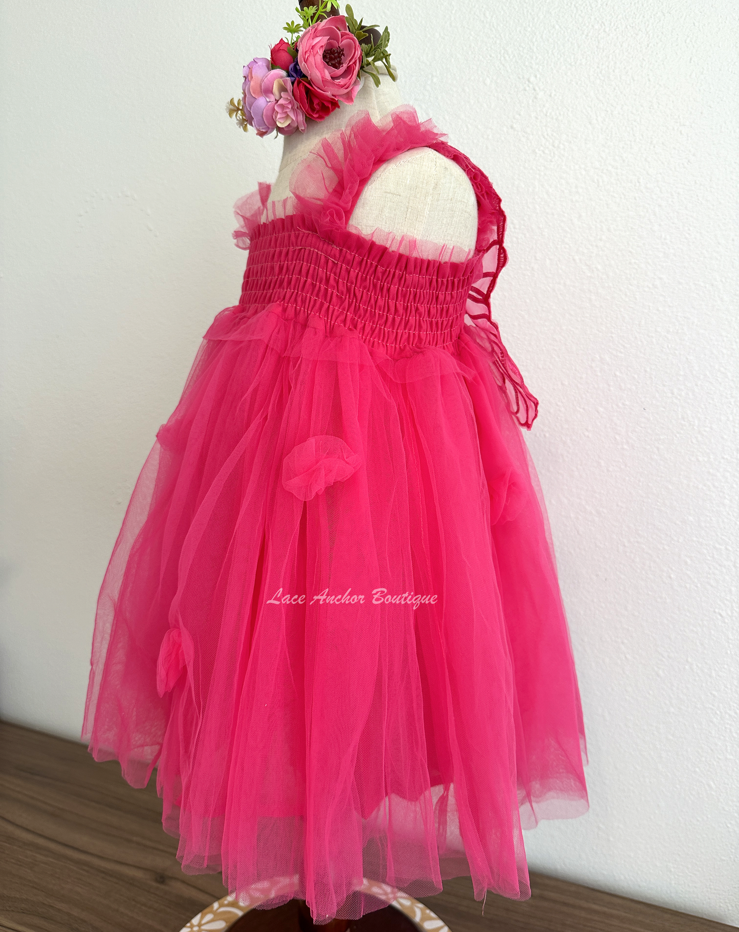 hot pink tulle fairy girls dress with smocked top and tulle flowers on skirt. Attached butterfly wings and ruffled straps.