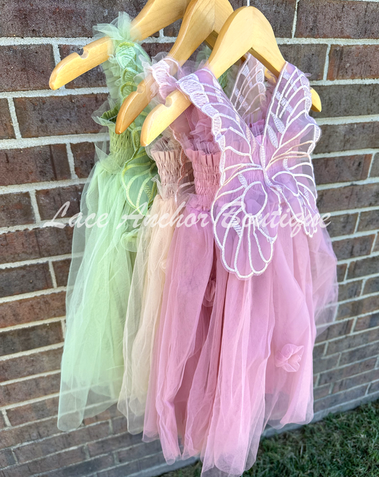 Sage green, champagne beige, and mauve pink tulle fairy girls dresses with smocked top and tulle flowers on skirt. Attached butterfly wings and ruffled straps.