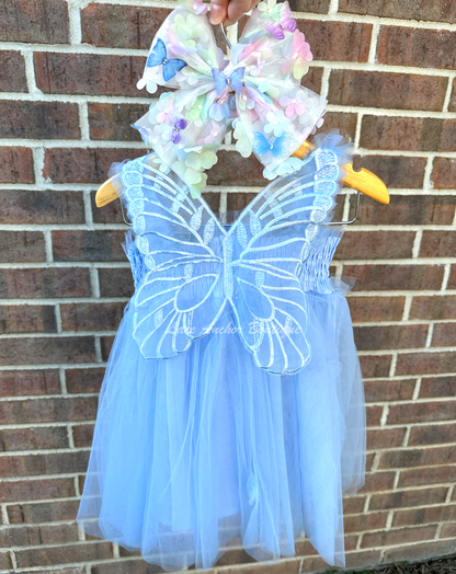 light blue tulle fairy girls dress with smocked top and tulle flowers on skirt. Attached butterfly wings and ruffled straps.