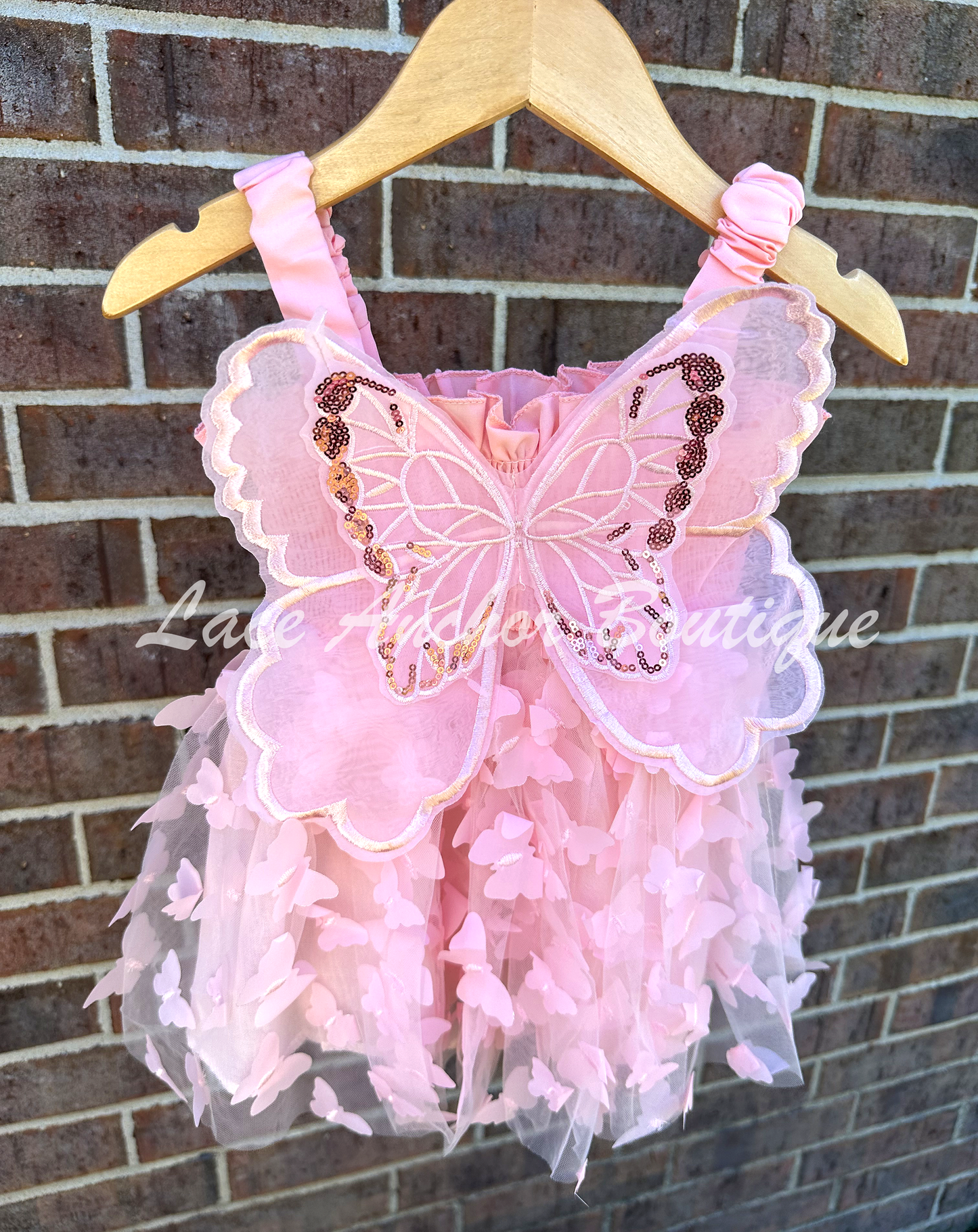 Light blush pale pink girls butterfly wing fairy dress in pink child toddler dress. Has butterflies all over skirt.