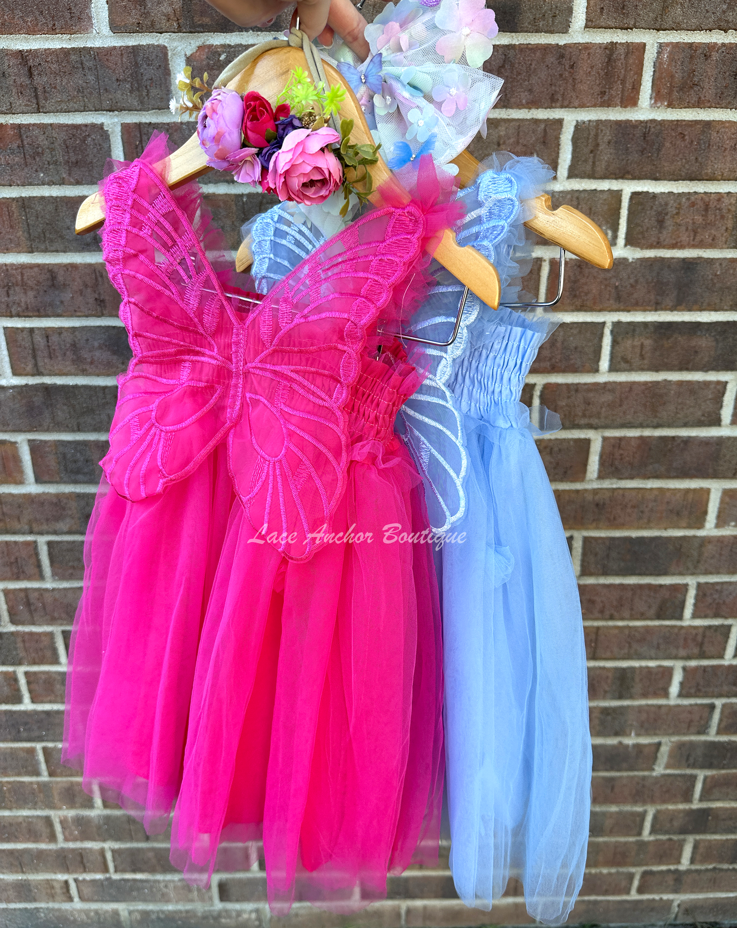 hot pink tulle or light blue fairy girls dresses with smocked top and tulle flowers on skirt. Attached butterfly wings and ruffled straps.