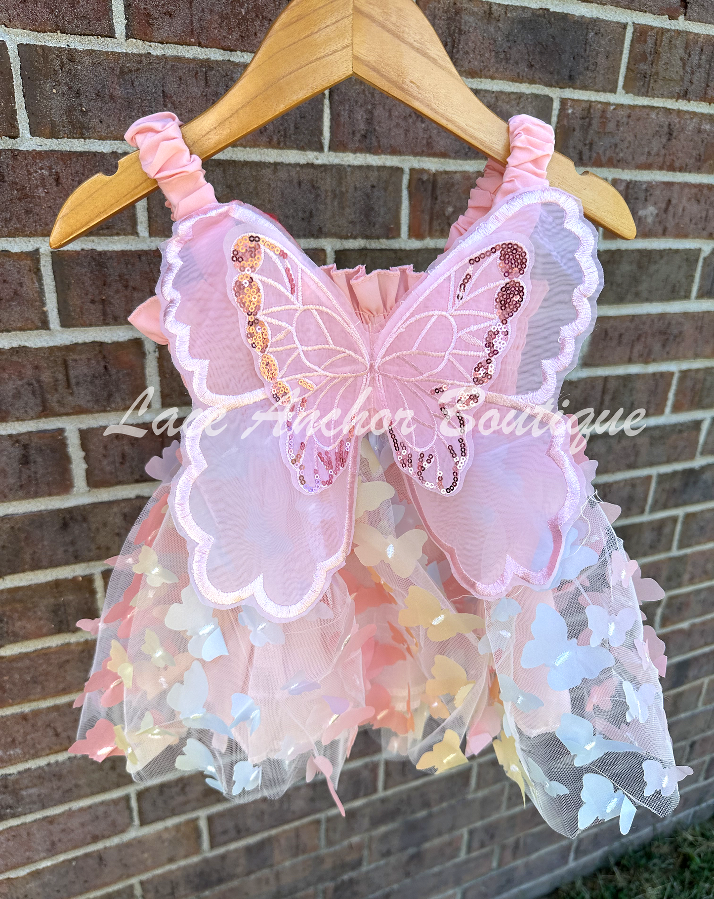 Light blush multi color pink girls butterfly wing fairy dress in pink child toddler dress. Has rainbow colored butterflies all over skirt.