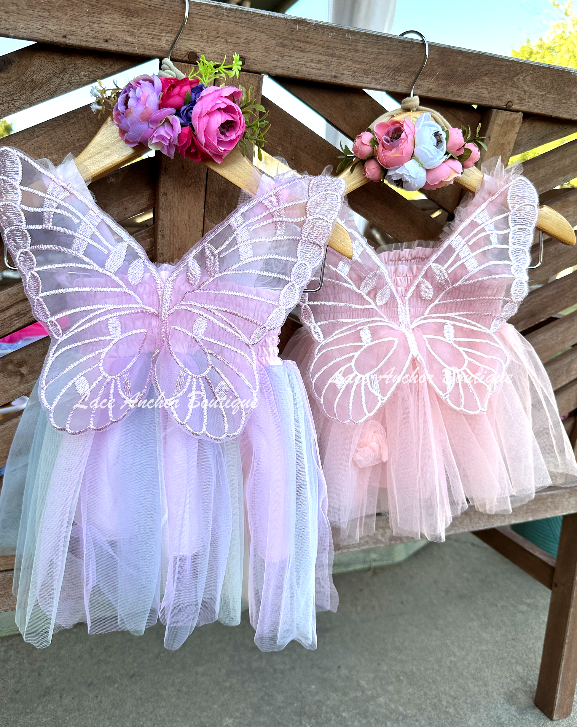 peachy with flowers or lilac, blue, pastel yellow, and blush colored tulle fairy girls dresses with smocked top and tulle flowers on skirt. Attached butterfly wings and ruffled straps.