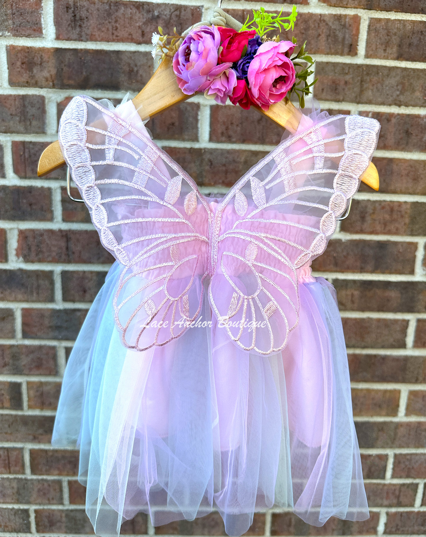 lilac, blue, pastel yellow, and blush colored tulle fairy girls dresses with smocked top and tulle flowers on skirt. Attached butterfly wings and ruffled straps.