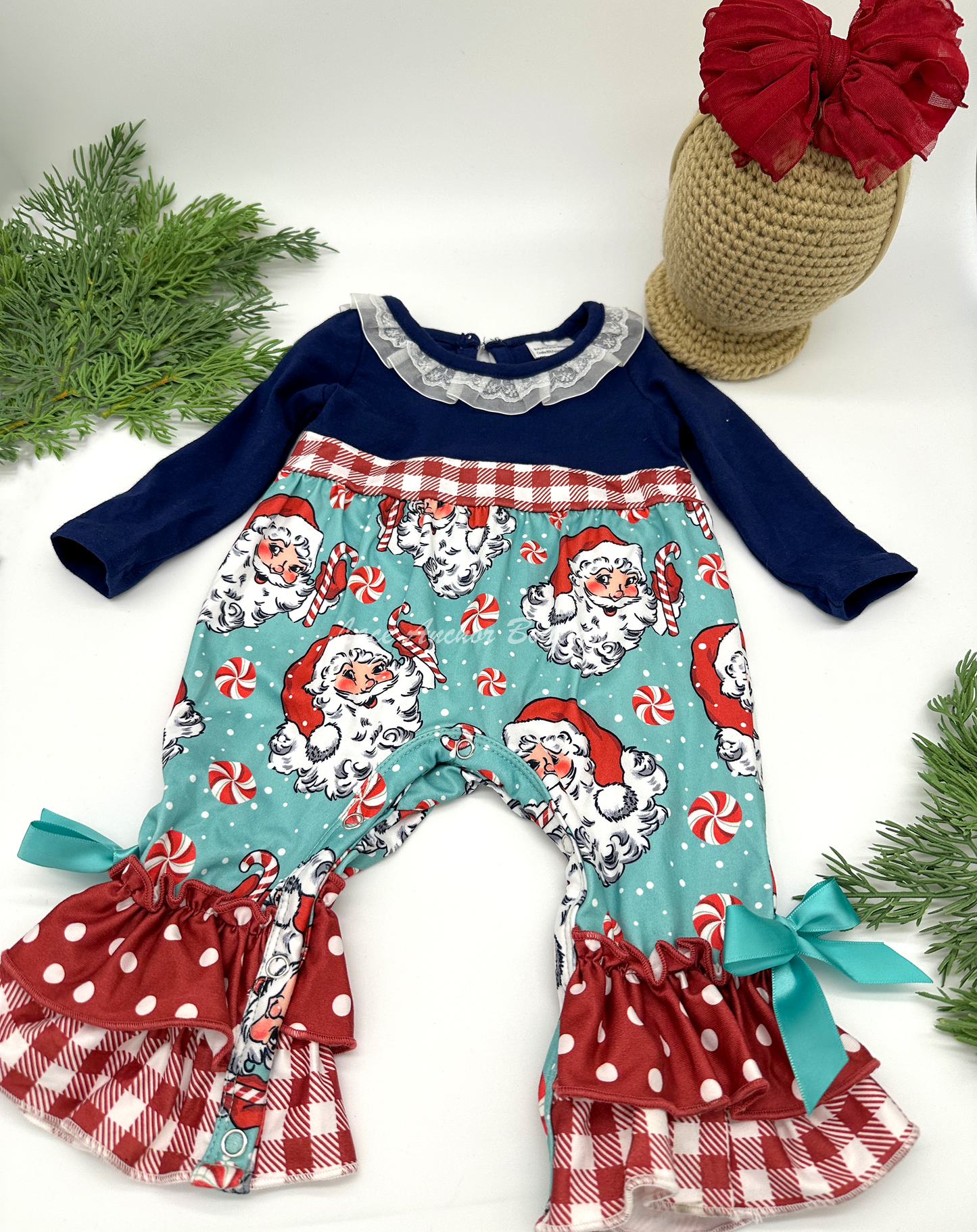 Santa Claus themed baby girls romper with candy canes, red gingham print, and lace collar.