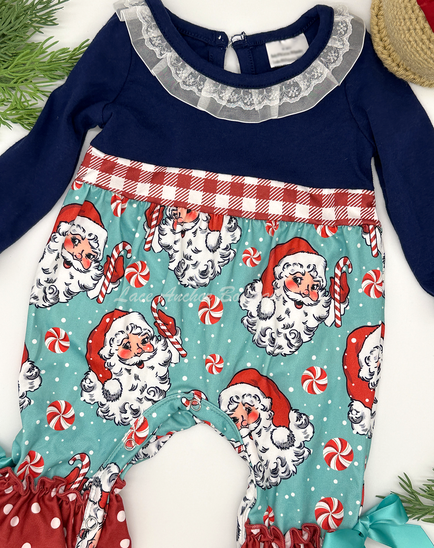 Santa Claus themed baby girls romper with candy canes, red gingham print, and lace collar.