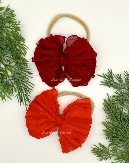 baby headband wrap on nylon band. Red and burgundy bows with ruffled texture.