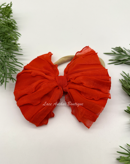 baby headband wrap on nylon band. Red bow with ruffled texture.