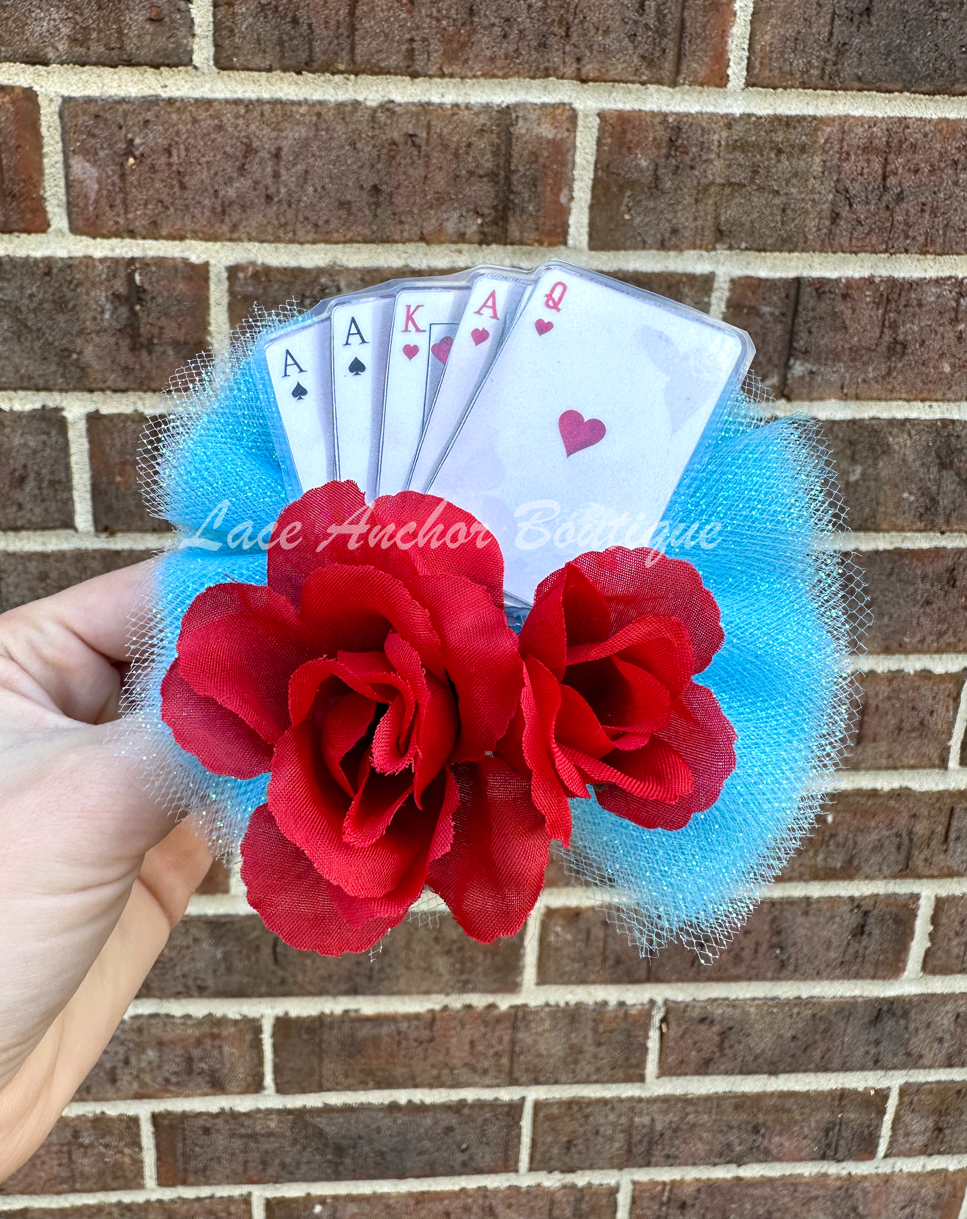 Alice in Wonderland themed girls clip hair bow with playing cards and red roses on a light blue tulle.